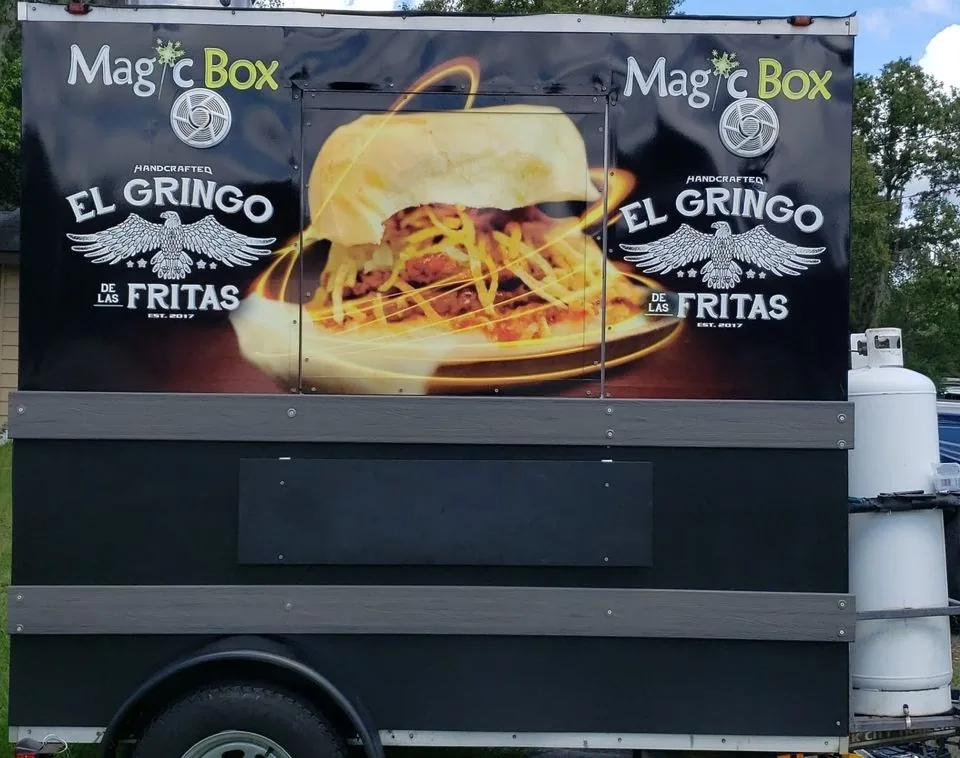 The Magic Box catering trailer wrapped with El Gringo de las Fritas logos and a frita sandwich